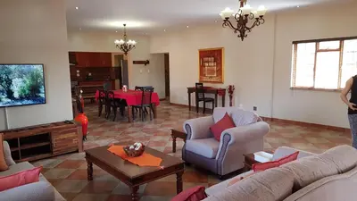 a living room with a couch and chairs and a table at Hornbills Rest Country Home in Phalaborwa