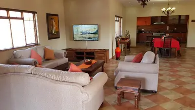 a living room with two couches and a table at Hornbills Rest Country Home in Phalaborwa