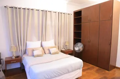a bedroom with a large white bed and wooden cabinets at Union Guesthouse in Pretoria