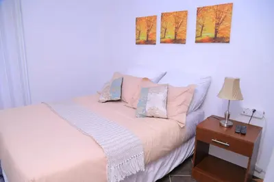 a bedroom with a bed and a table with a lamp at Union Guesthouse in Pretoria