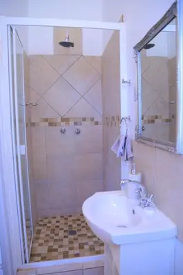 a bathroom with a shower and a sink and a shower at Union Guesthouse in Pretoria