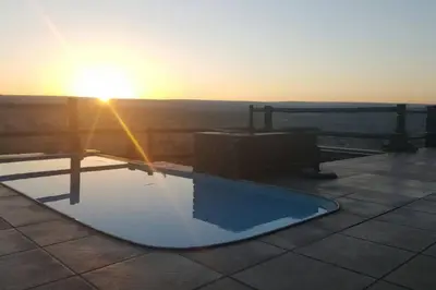 a swimming pool with the sunset in the background at Kubu Khaya Mabalingwe in Mabula