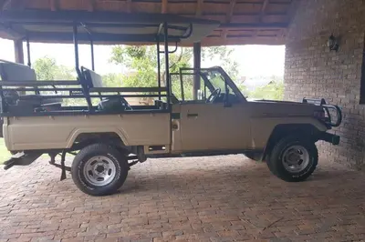 a tan jeep parked in front of a building at Kubu Khaya Mabalingwe in Mabula