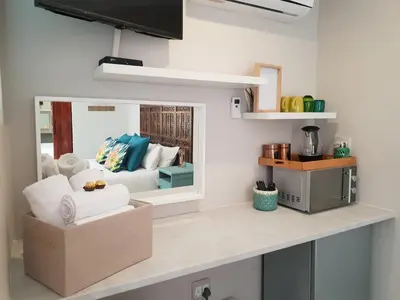 a living room with a couch and a mirror at NOOii Open Plan Room in Pretoria