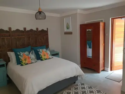 a bedroom with a large bed with blue and orange pillows at NOOii Open Plan Room in Pretoria