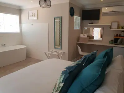 a bedroom with a bed and a tub and a sink at NOOii Open Plan Room in Pretoria