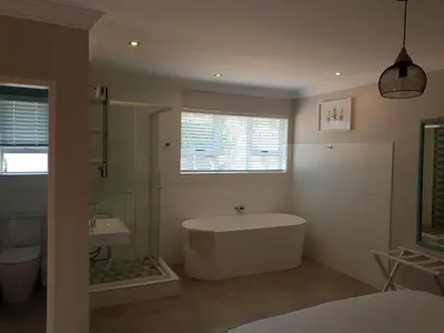 a bathroom with a bath tub and a sink at NOOii Open Plan Room in Pretoria