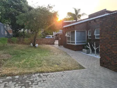 a brick house with two animals standing in the yard at NOOii Open Plan Room in Pretoria