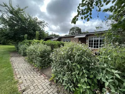 a brick path in front of a house with bushes at Halleria Self Catering in White River