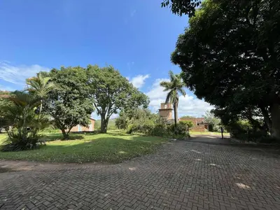 a cobblestone road with trees and a building in the distance at Halleria Self Catering in White River
