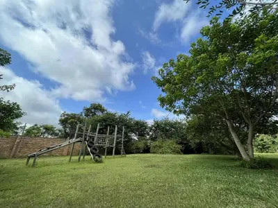 a playground in a field with a tree at Halleria Self Catering in White River