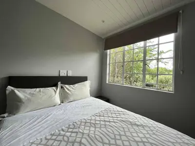 a bedroom with a large bed and a window at Halleria Self Catering in White River