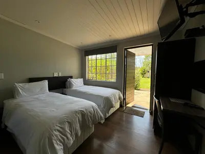a bedroom with two beds and a sliding glass door at Halleria Self Catering in White River