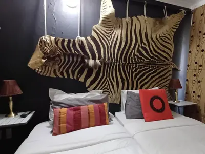 a bedroom with a bed with a zebra head board at Wooden Creek Estate in Kempton Park