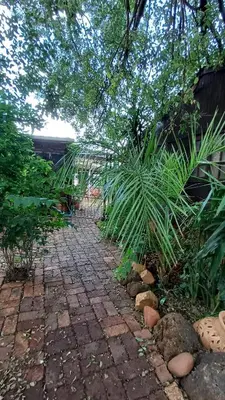 a garden with a brick walkway and some plants at Wooden Creek Estate in Kempton Park