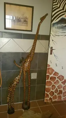 two giraffes on the wall in a bathroom at Wooden Creek Estate in Kempton Park