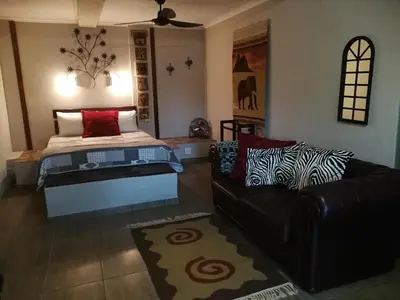 a living room with a bed and a couch at Meerkat Manor in Komatipoort