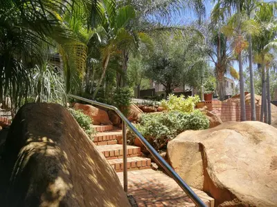 a set of stairs in a garden with palm trees at Meerkat Manor in Komatipoort