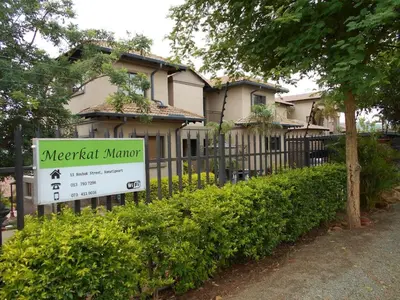 a house with a sign in front of a fence at Meerkat Manor in Komatipoort