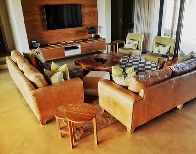 a living room with leather furniture and a flat screen tv at Jacana River Lodge Mjejane Game Reserve in Hectorspruit