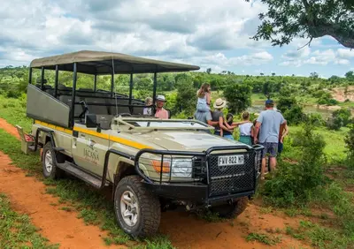 a group of people standing around a jeep on a dirt road at Jacana River Lodge Mjejane Game Reserve in Hectorspruit