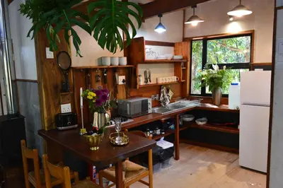 a kitchen with a table and a sink and a refrigerator at Waterbessiebos cottage in Tzaneen