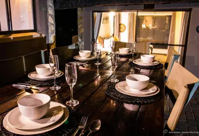 a wooden table with plates and cups and wine glasses at Lindanda Luxury Lodge in Hoedspruit