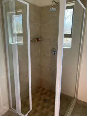 a shower with a glass door in a bathroom at Lindanda Luxury Lodge in Hoedspruit