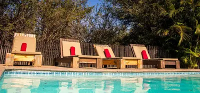 a group of chairs sitting next to a swimming pool at Lindanda Luxury Lodge in Hoedspruit