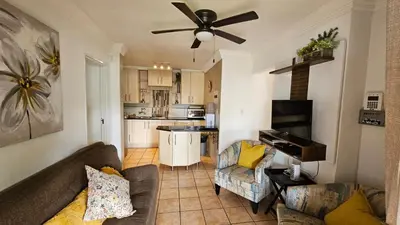 a living room with a couch and a ceiling fan at Pont de Fleur in Hartbeespoort