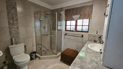 a bathroom with a shower and a toilet and a sink at Pont de Fleur in Hartbeespoort