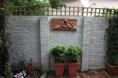 a painting of a man on a wall with plants at Panda's Guest Cottages in Kaapsehoop