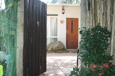 an entrance to a house with a wooden door at Panda's Guest Cottages in Kaapsehoop