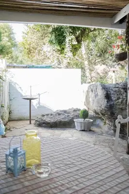 a view of a patio with a table and a rock wall at Panda's Guest Cottages in Kaapsehoop