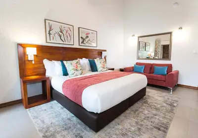 a bedroom with a large bed and a red couch at Kruger Park Lodge Unit No. 608A in Hazyview