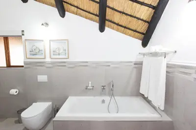 a bathroom with a white tub and a toilet at Kruger Park Lodge Unit No. 608A in Hazyview