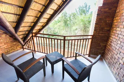 a porch with two chairs and a table on a balcony at Kruger Park Lodge Unit No. 610A in Hazyview