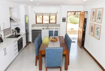a kitchen with a wooden table and blue chairs at Kruger Park Lodge Unit No. 610B in Hazyview
