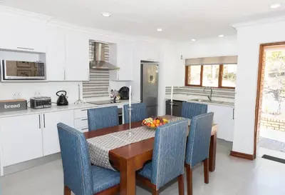 a kitchen and dining room with a table and chairs at Kruger Park Lodge Unit No. 610B in Hazyview