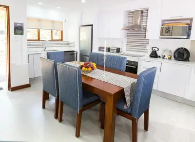a kitchen with a wooden table and blue chairs at Kruger Park Lodge Unit No. 610B in Hazyview
