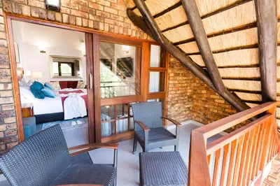 a room with two chairs and a bed at Kruger Park Lodge Unit No. 610B in Hazyview