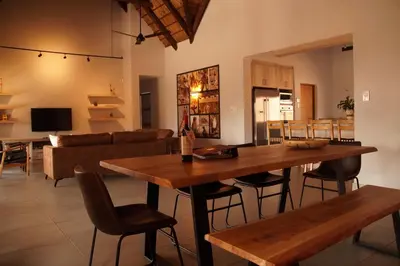 a living room with a wooden table and chairs at Uchawi wa Afrika in Marloth Park