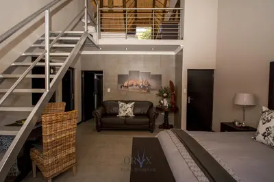 a living room with a staircase and a couch at Oryx B&B Reserved Guests Only in Mokopane