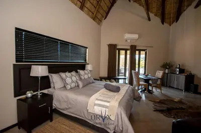 a bedroom with a bed and a table and chairs at Oryx B&B Reserved Guests Only in Mokopane