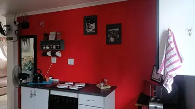 a red wall with a counter in a room at King Protea Self Catering Accommodation in Erasmuskloof, Pretoria East in Pretoria