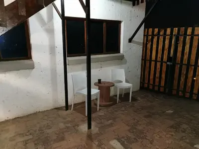 two chairs and a table in a room with windows at King Protea Self Catering Accommodation in Erasmuskloof, Pretoria East in Pretoria