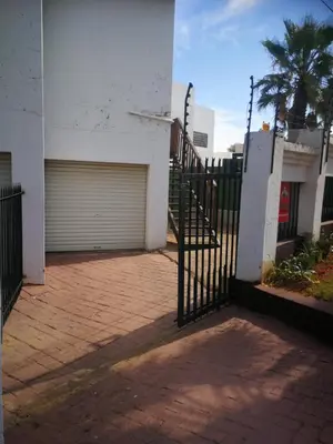 a gate to a building with a garage at King Protea Self Catering Accommodation in Erasmuskloof, Pretoria East in Pretoria