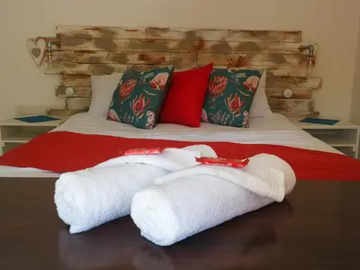 a bed with two white towels on it at King Protea Self Catering Accommodation in Erasmuskloof, Pretoria East in Pretoria
