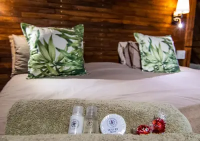 a bed with two bottles of detergents on it at The South Post @ Kruger in Marloth Park