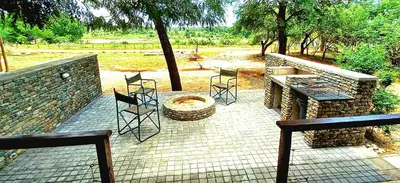 a patio with chairs and a grill and a fire pit at The South Post @ Kruger in Marloth Park